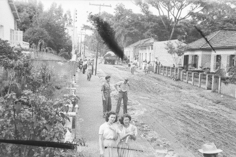 Outra imagem da rua Presidente Vargas; ao fundo, moradores e funcionários da prefeitura trabalham na retirada da lama.